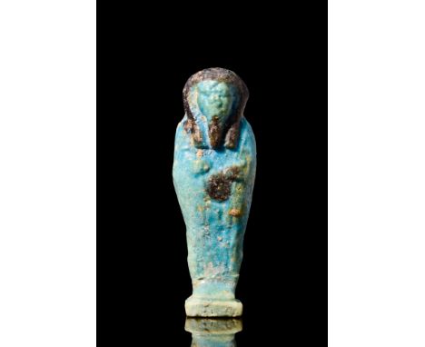 Late to Ptolemaic Period, Ca. 664-30 BC.A beautiful mummiform ushabti decorated with a light blue glaze and applied black pig