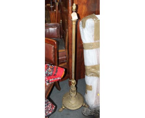 A brass standard lamp with reeded column and three paw feet, 52" high 