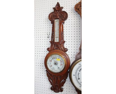A Victorian aneroid barometer and thermometer, in carved oak case, 27" high 