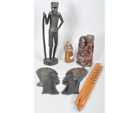 A collection of assorted carved wooden items to include; African male and female carved plaques, male figure, monk, buddha la