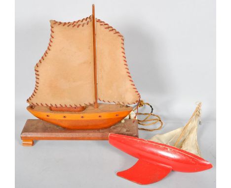 An early 20th century wooden sailing boat lamp and a red painted wooden pond sailing boat