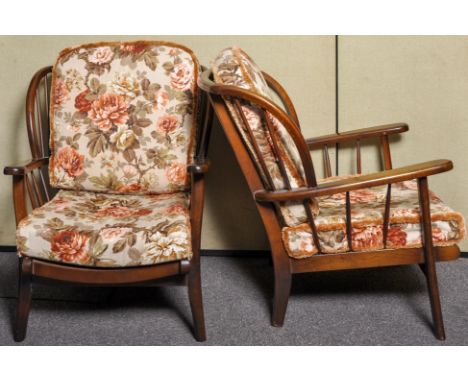A pair of 1980's Ercol style retro vintage armchairs having spindle backrest, shaped arms and raised on shaped legs along wit