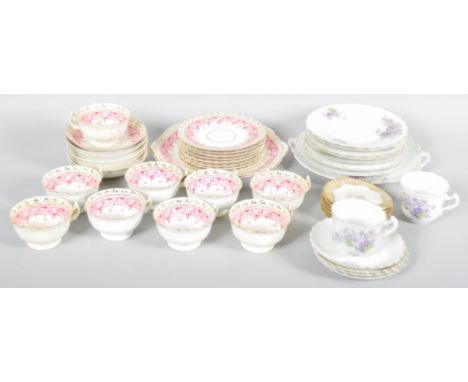 A 19th Century part tea service with gilt and floral borders along with a later set having purple floral transfers.