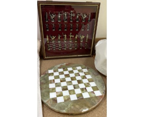 A two tone metal chess set contained within a glass display cabinet together with a circular onyx chess board 