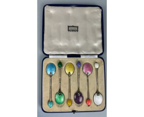 A SET OF SIX SILVER AND COLOURED GUILLOCHE ENAMEL SPOONS, In an antique harrods case. 45gms 