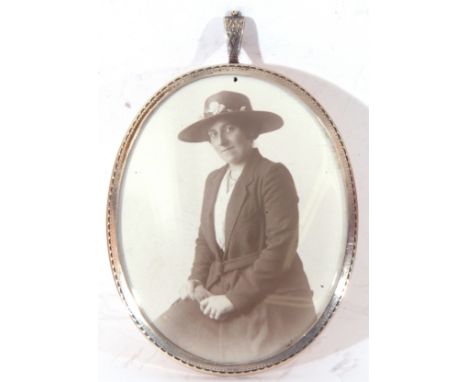 George V silver mounted photograph frame of oval form fitted with suspension loop, containing a black and white portrait phot