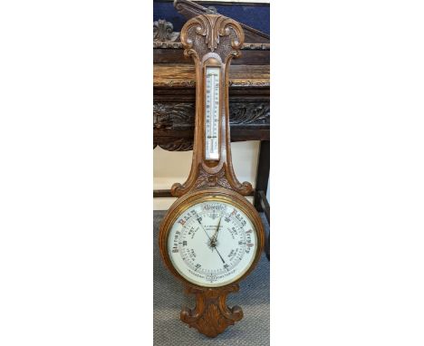 An early 20th century oak carved aneroid barometer, the dial inscribed R.J Whitehall Newport, 96cm h x 31.5cm Location: 