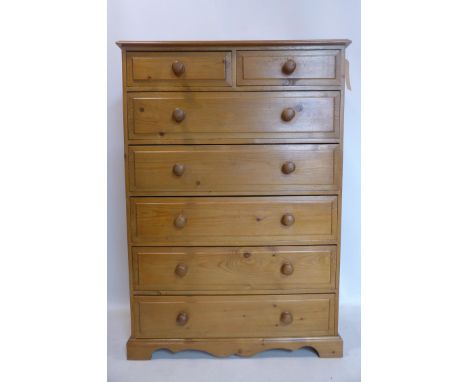 A 20th century pine chest of two small over five long drawers, raised on bracket feet with shaped apron, H.130 W.91 D.41cm 
