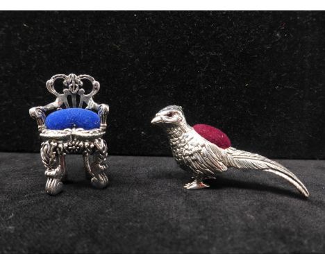 Two sterling silver pin cushions in the form of a miniature chair, 3.8 x 2.2cm, and a pheasant with ruby eyes, 3 x 5cm, Gross