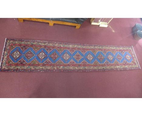 A North West Persian Heriz runner, repeating stylised pole medallion on a light blue field, within stylised geometric border,