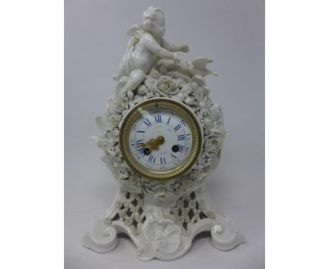 A 19th century porcelain mantle clock in the Baroque taste adorned with putti and dove final, with white enamel dial with blu