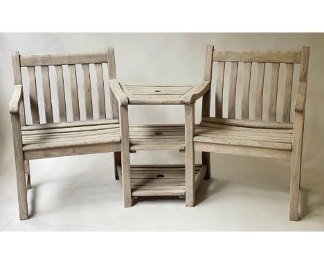 CONVERSATION BENCH BY ALEXANDER ROSE, weathered slatted teak with two armchairs and conjoined three shelf table, 180cm W. 