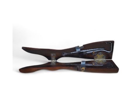 A Victorian rosewood 'ladys foot' etui holding a pair of steel bootpulls with additional tools to the handle, 26.5cm. Conditi
