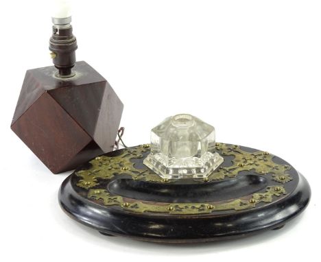 A Victorian ebonised and brass mounted inkwell, of oval form, with facetted glass well (AF), 30cm W, and a lamp base. (2)