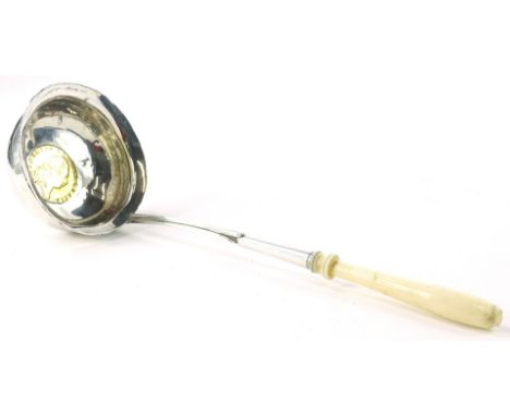 A white metal toddy ladle, the bowl inset with a George III 1798 gold spade guinea, and with a turned ivory handle.