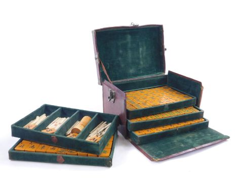 An early 20thC oriental Mahjong set, with various bone markers, composition pieces, in a leather case etc.