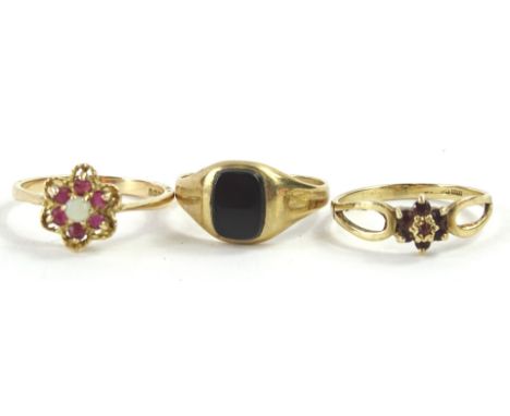 Three 9ct gold dress rings, to include a floral dress ring, set with garnet and opal, a gent's signet ring set with black aga