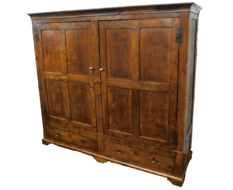 An oak cupboard, with moulded corners above two panelled doors, enclosing a line of pegs above two drawers on bracket feet, c