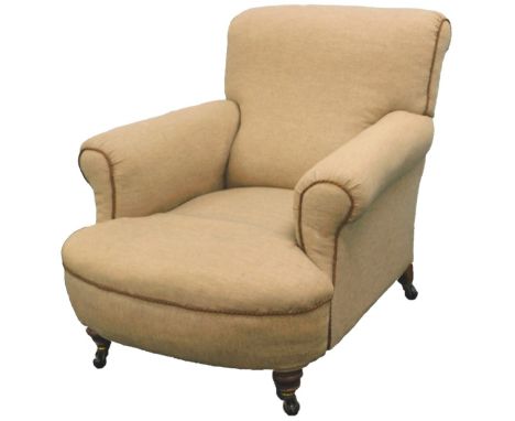 A Victorian mahogany arm chair in Howard style, upholstered in brown tweed fabric, on short turned legs with ceramic castors.