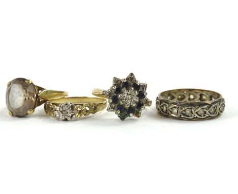 Four various dress rings, to include a 9ct gold smoky quartz set dress ring, a 9ct gold floral dress ring, a 9ct gold and sil