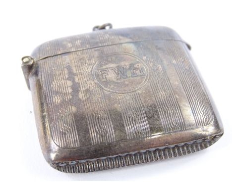 A George V silver vesta case, with engine turned decoration, around a central circular cartouche, engraved with initials FWH,