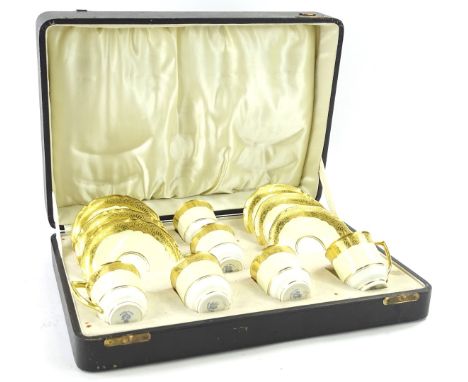 A cased Royal Worcester six piece coffee service, comprising of cups, 7cm H and saucers in gilt highlights on cream and white