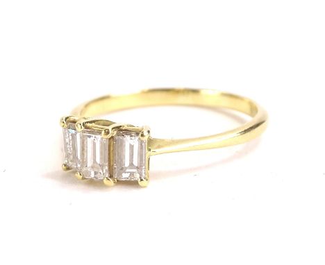 A diamond dress ring, set with three baguette diamonds, totalling approx 1.2cts overall, in claw setting on yellow metal band