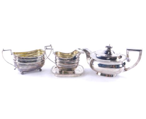 An associated George III silver tea service, each piece of rectangular form with a gadrooned edge, comprising teapot, milk ju