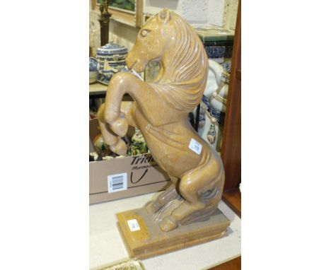 A glazed ceramic sculpture of a horse rearing and standing on its hind legs, on rectangular plinth, 51cm high.