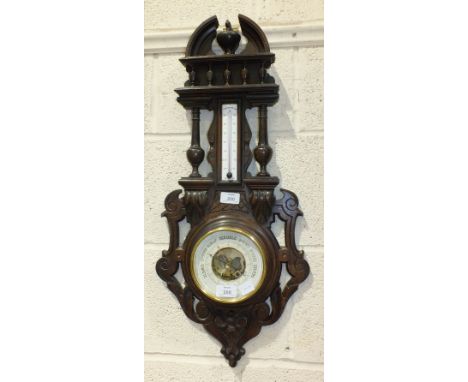 A French aneroid barometer/thermometer in carved stained wood frame, 69cm overall, barometer 14cm diameter.