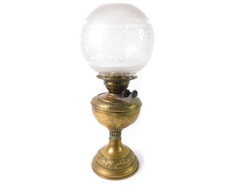 A duplex early 20thC brass oil lamp, with embossed rococo scroll and foliate decoration, with a clear and frosted globular gl