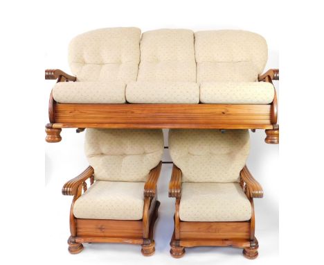 A pine three piece cottage suite, with brown button back cushions and seats, with fluted arms, raised on bun feet, comprising