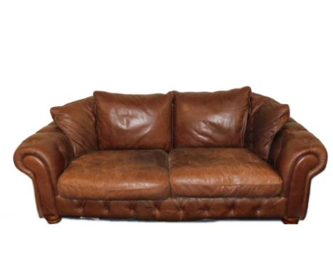 A brown leather two seater sofa, with button upholstered front and arms, two cushion seats and four back cushions, 227cm W.