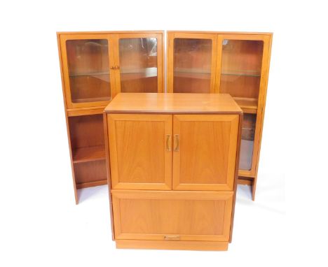 A G-Plan late 20thC teak cabinet, with two glazed doors opening to reveal a single glass shelf, above a further shelf, 144.5c