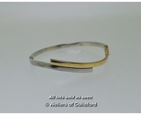 *Hinged bangle in a wavy design in silver and yellow metal stamped as 9ct, weight 7.0 grams (Lot subject to VAT)