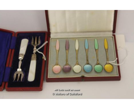 A set of six silver gilt and enamel coffee spoons by Fribast, Denmark, boxed; a pair of silver plated pickle forks with mothe