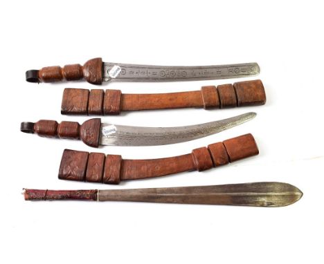 Two Tuareg Short Swords, each with curved double edge steel blade stamped with roundels and scalloping, with leather bound hi