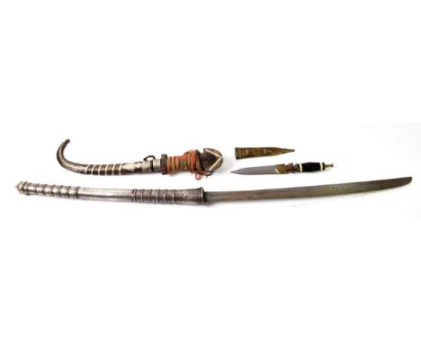 A Late 19th Century Burmese Dha, with 53.5cm single edge steel blade, the silver covered long cylindrical hilt with ringed de