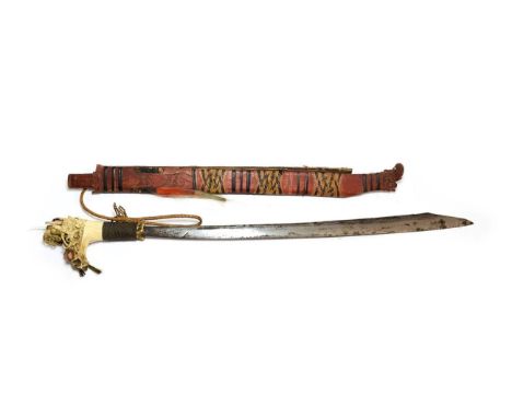 A Dyak Head Hunter's Mandau, with 57cm clip point steel blade, the bone hilt with woven brass grip, the angled pommel carved 