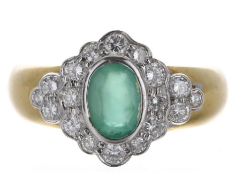 18ct emerald and diamond oval cluster ring, the emerald 0.70ct approx, set in white metals in a surround of round brilliant-c