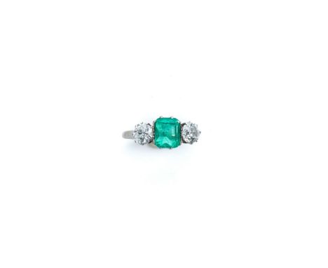 EMERALD AND DIAMOND RING the step-cut emerald claw set between two circular diamonds, shank split to the base size K 