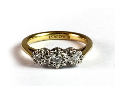 An 18ct yellow gold and platinum (stamped 18ct & plat) three diamond ring (K).