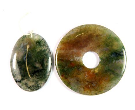 A Chinese spinach jade amulet, L. 5cm and a spinach jade pi disc, Dia. 6cm.