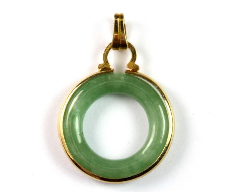 A yellow metal mounted polished jade pendant, Dia. 2.2cm.