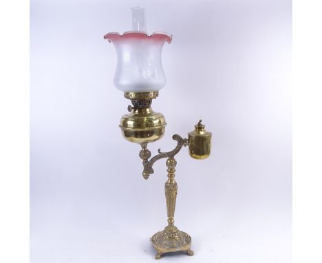 A 19th century brass oil lamp, relief embossed cherub base with frosted frilled glass shade and clear glass chimney, overall 