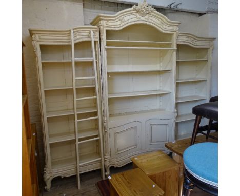A Continental cream painted 3-section library bookcase, with adjustable shelves, and panelled cupboards to the centre, with l