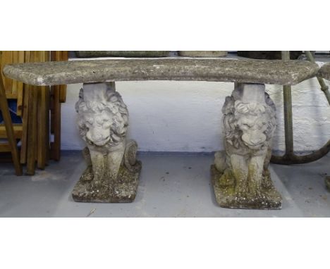 A weathered concrete curved garden bench on lion supports, W120cm 