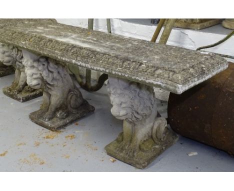 A weathered rectangular concrete garden bench on lion supports, W112cm 