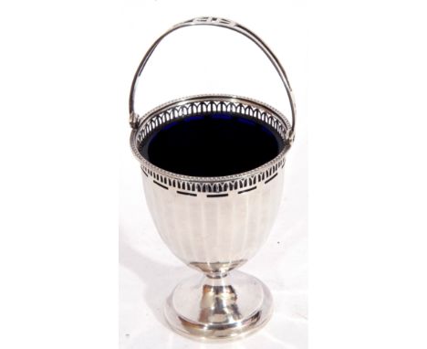 George V silver sugar basket featuring a panelled fluted pierced architectural border, swing handle on a spreading stepped fo