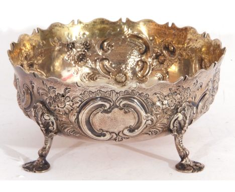 Victorian silver sugar bowl, circular form, of George II design, embossed and chased with flowers and scrolls, supported on f